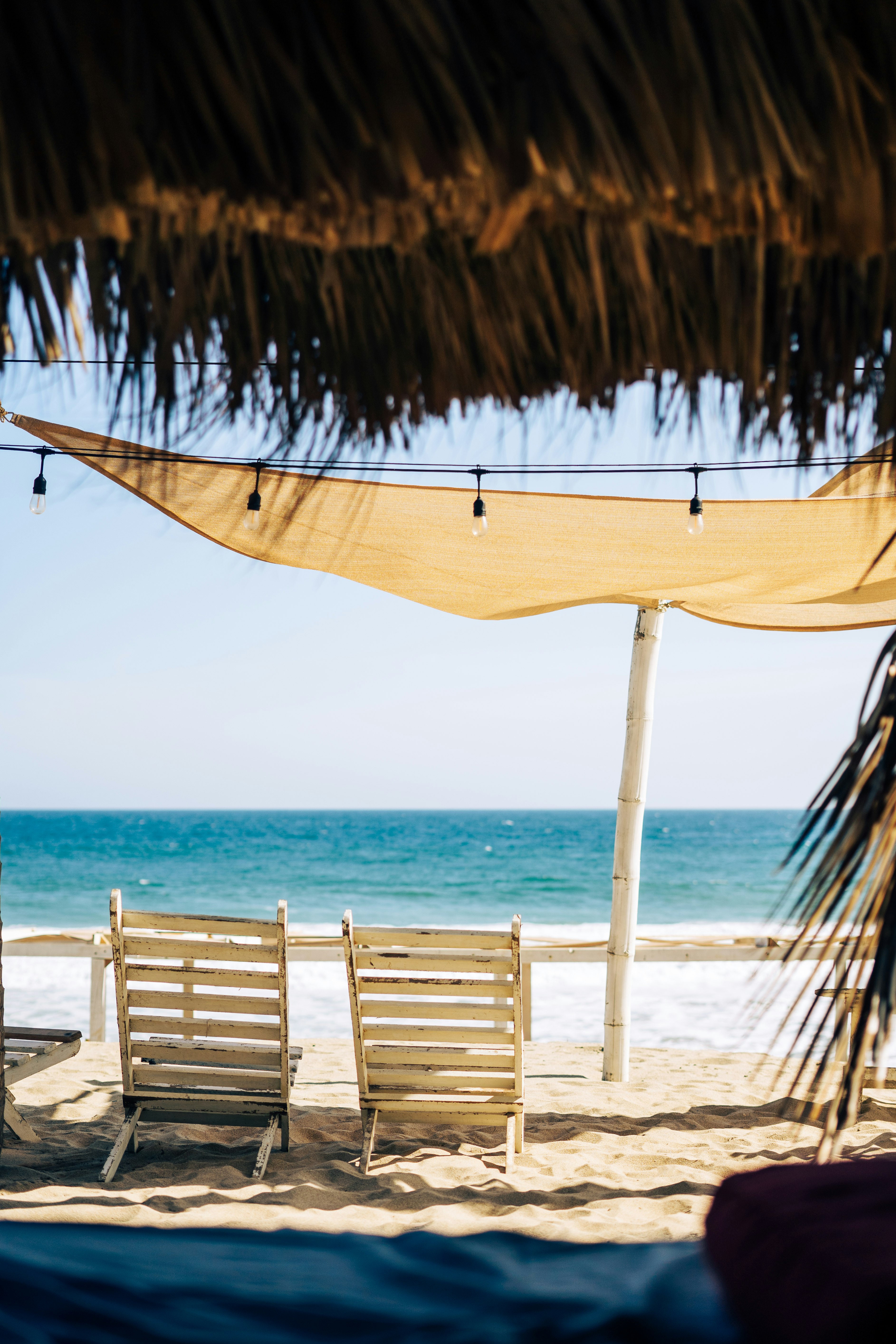 brown wooden beach lounge chairs on beach during daytime